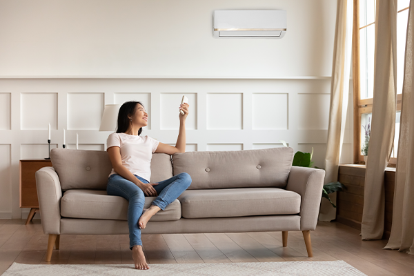 Woman lounging in living room changing a/c temperature